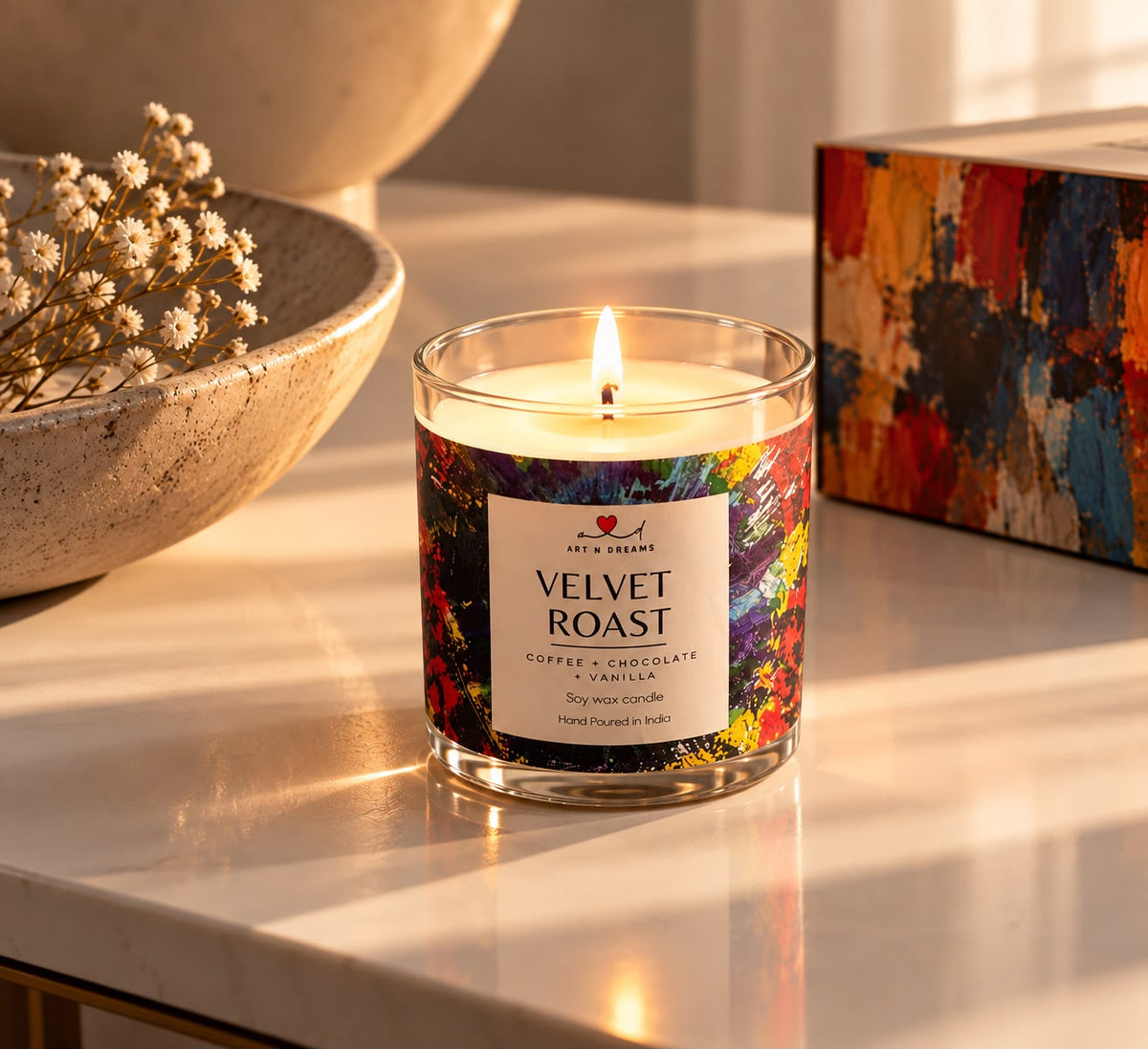 Velvet Roast candle on marble surface with flowers